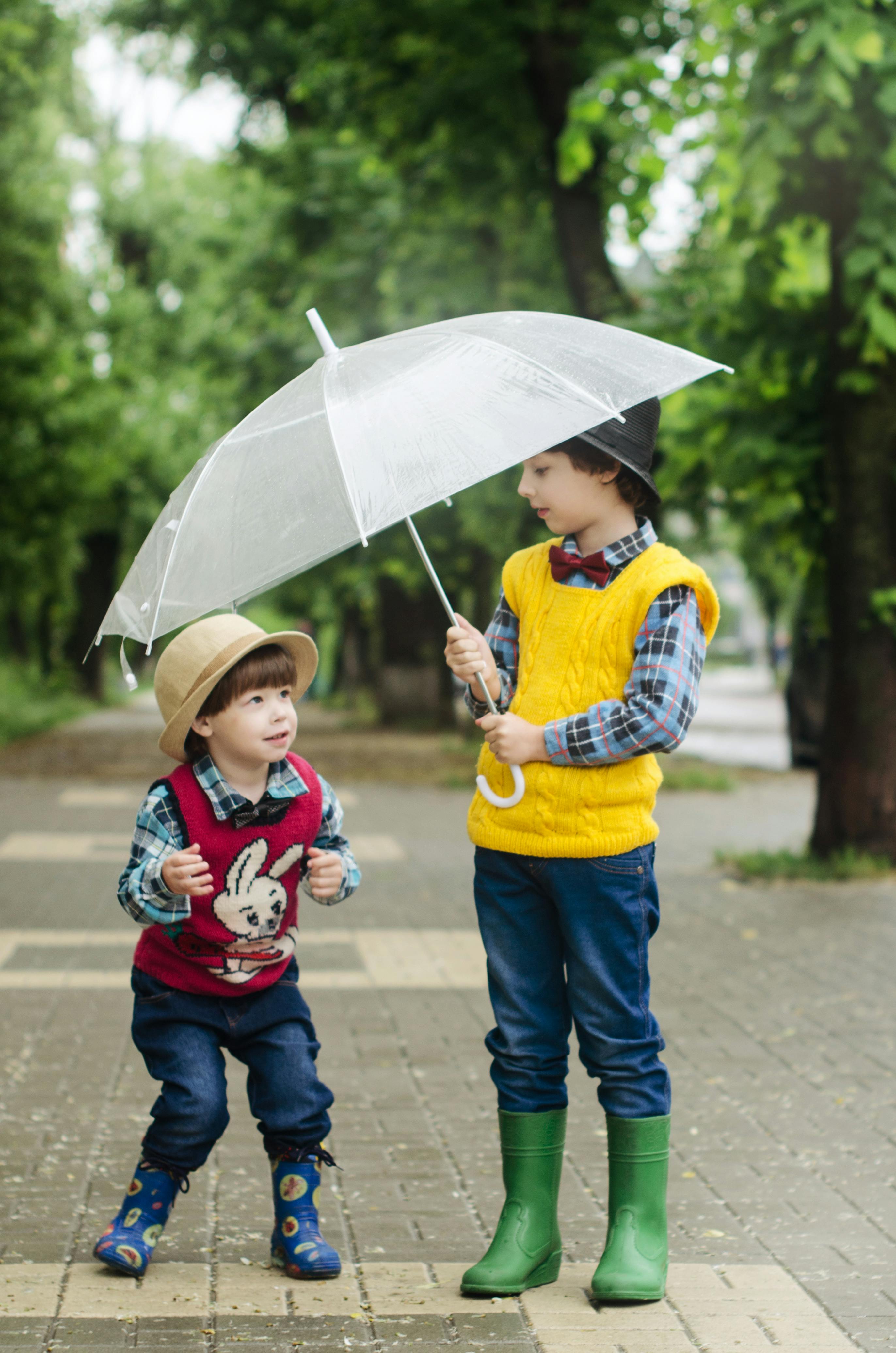 Toddler Holding Umbrella Beside Girl · Free Stock Photo