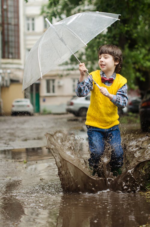 Junge Hält Klaren Regenschirm