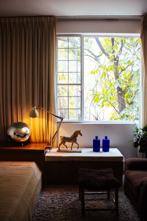 Free Elegant bedroom interior with classic decor and a large window overlooking greenery. Stock Photo