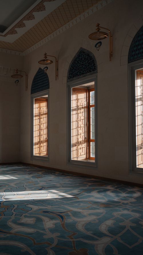 Free Sunlit interior of a mosque showcasing ornate windows and ottoman architecture. Stock Photo