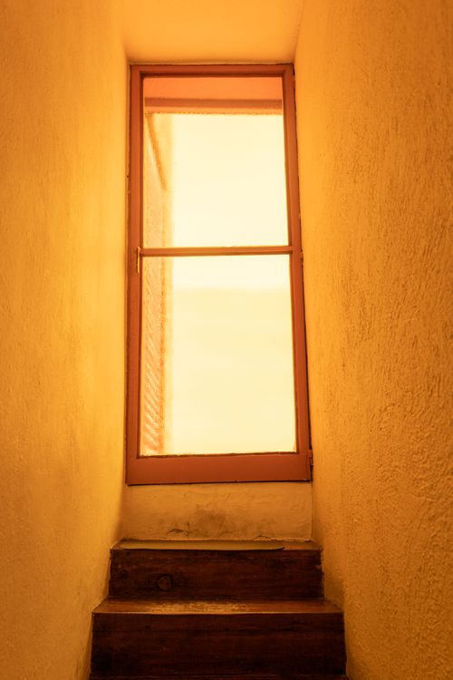 Free Warm light filters through a frosted glass door at the top of wooden steps. Stock Photo