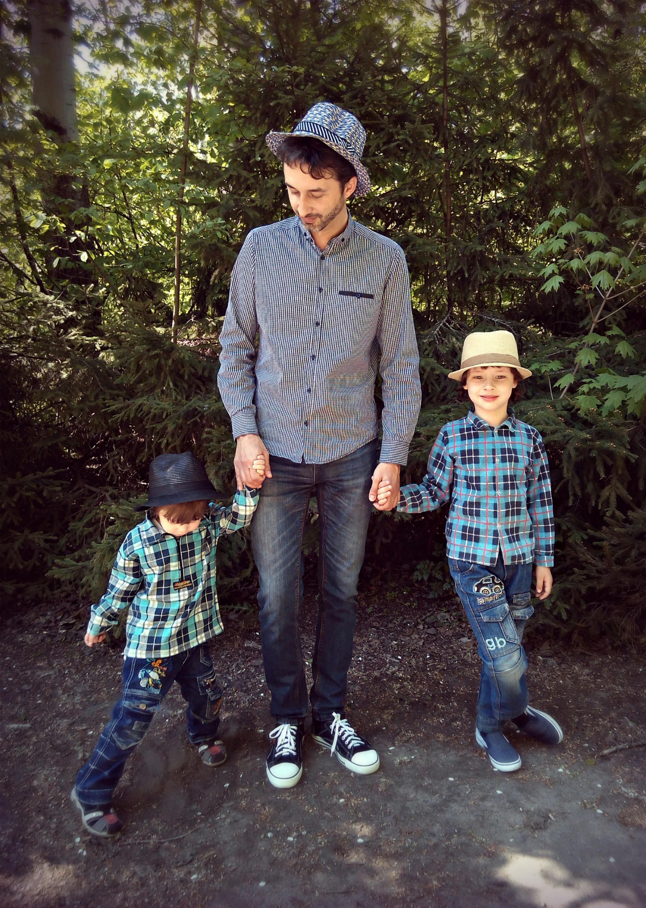 阳光明媚的日子里，父亲和儿子们在公园里牵着手微笑