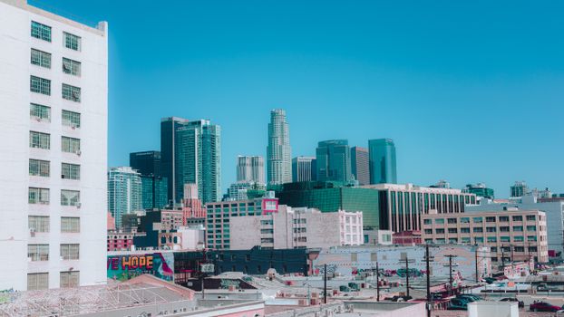 Colorful view of Los Angeles skyline under a clear blue sky, capturing urban life.
