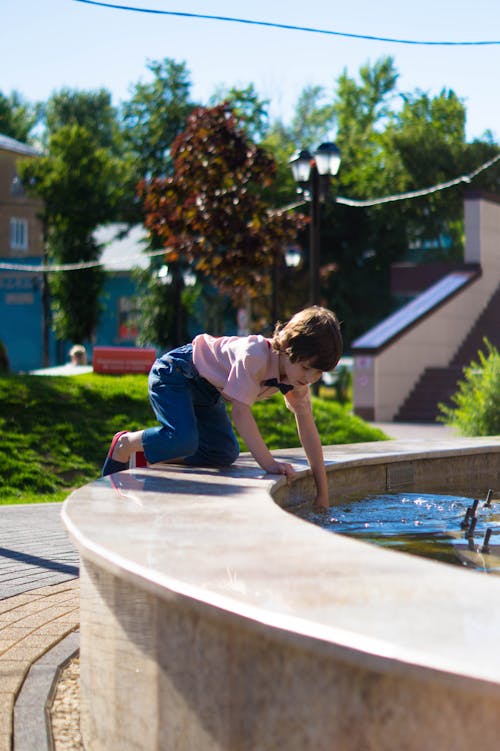 Boy Playing On Outdoor Water Fountain