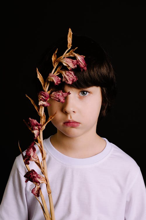 Free Boy in White Crew-neck Shirt Holding Pink Petaled Flowers Stock Photo