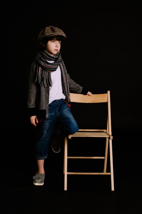 Boy Holding Brown Wooden Chair