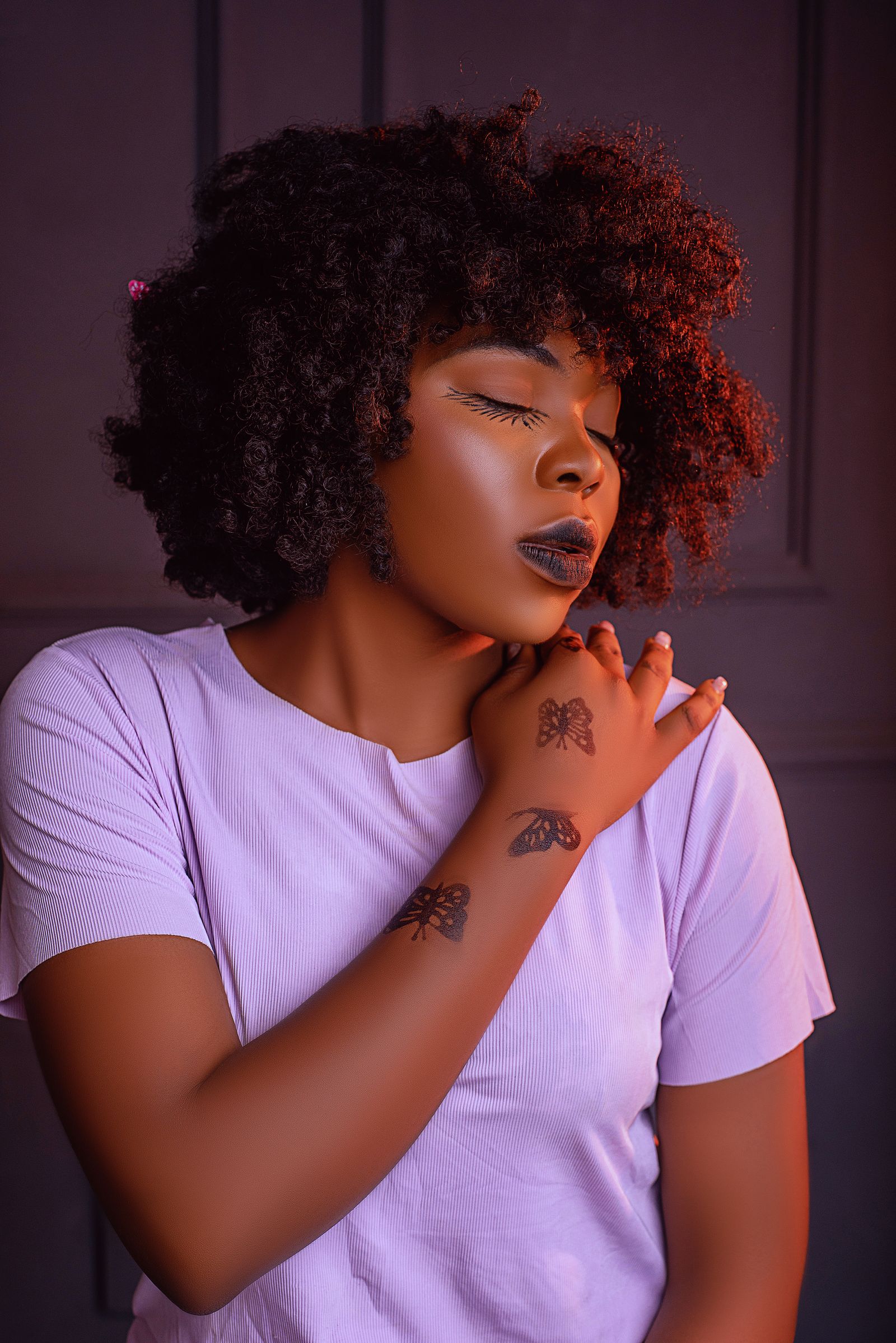 Tattooed woman with afro hair in a studio session