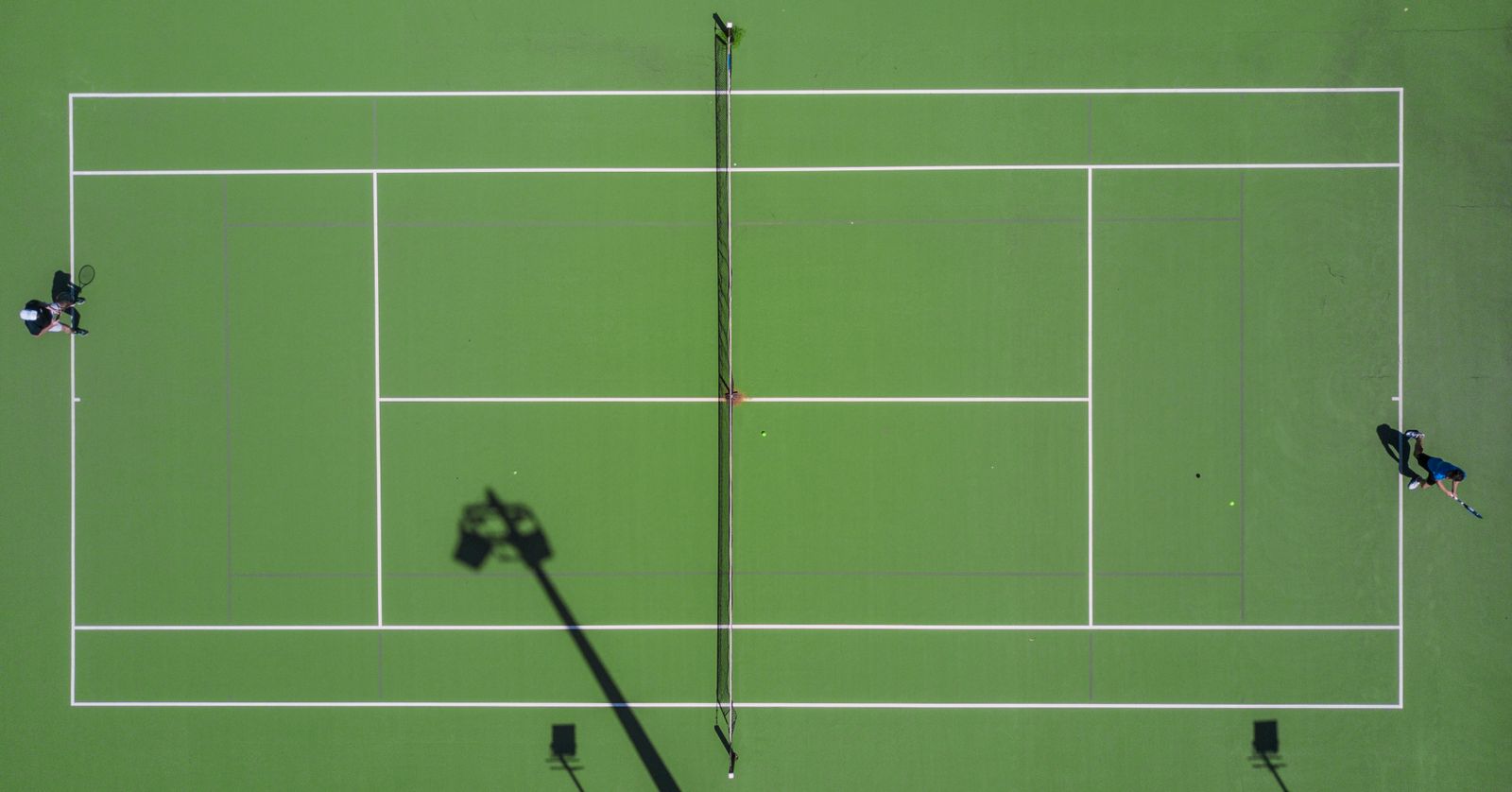 Tennis players on court, matching knee compression sleeve selection for tennis movement. Photo: Pexels.