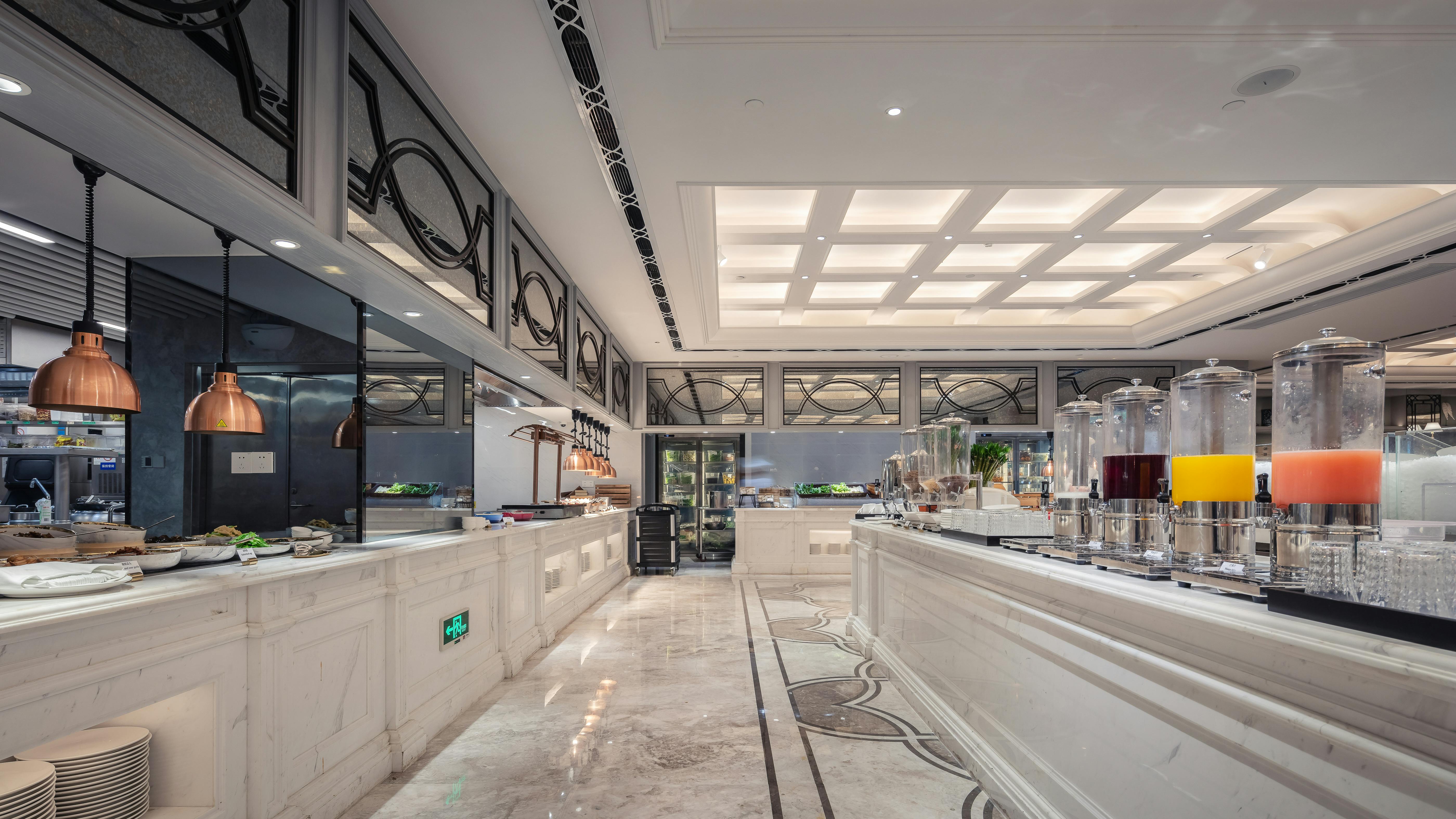 Luxurious hotel buffet area featuring elegant interior design and a variety of juices.