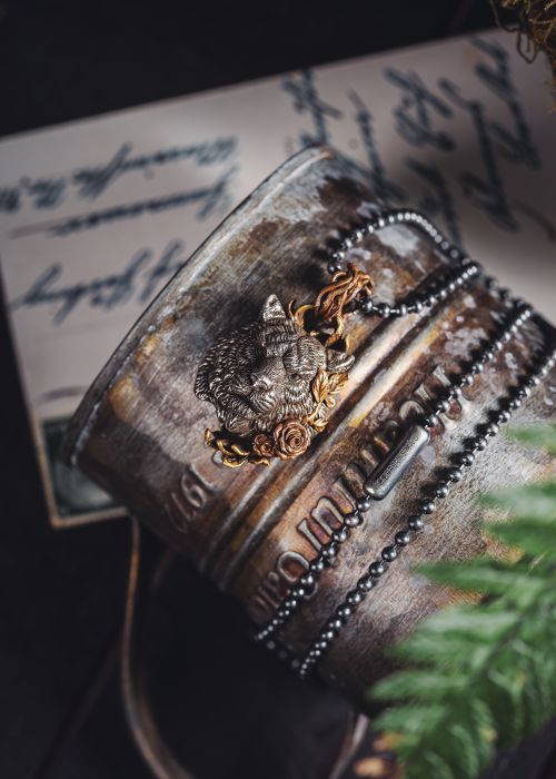 Free Detailed image of a metal tiger pendant bracelet wrapped onto a vintage surface, capturing intricate craftsmanship. Stock Photo