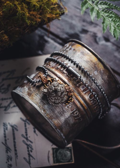 Free Close-up of an ornate metal pendant on a vintage surface with rustic elements. Stock Photo