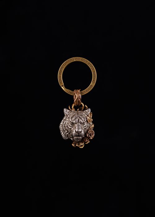 Free Close-up of a detailed tiger pendant featuring floral designs on a dark backdrop. Stock Photo