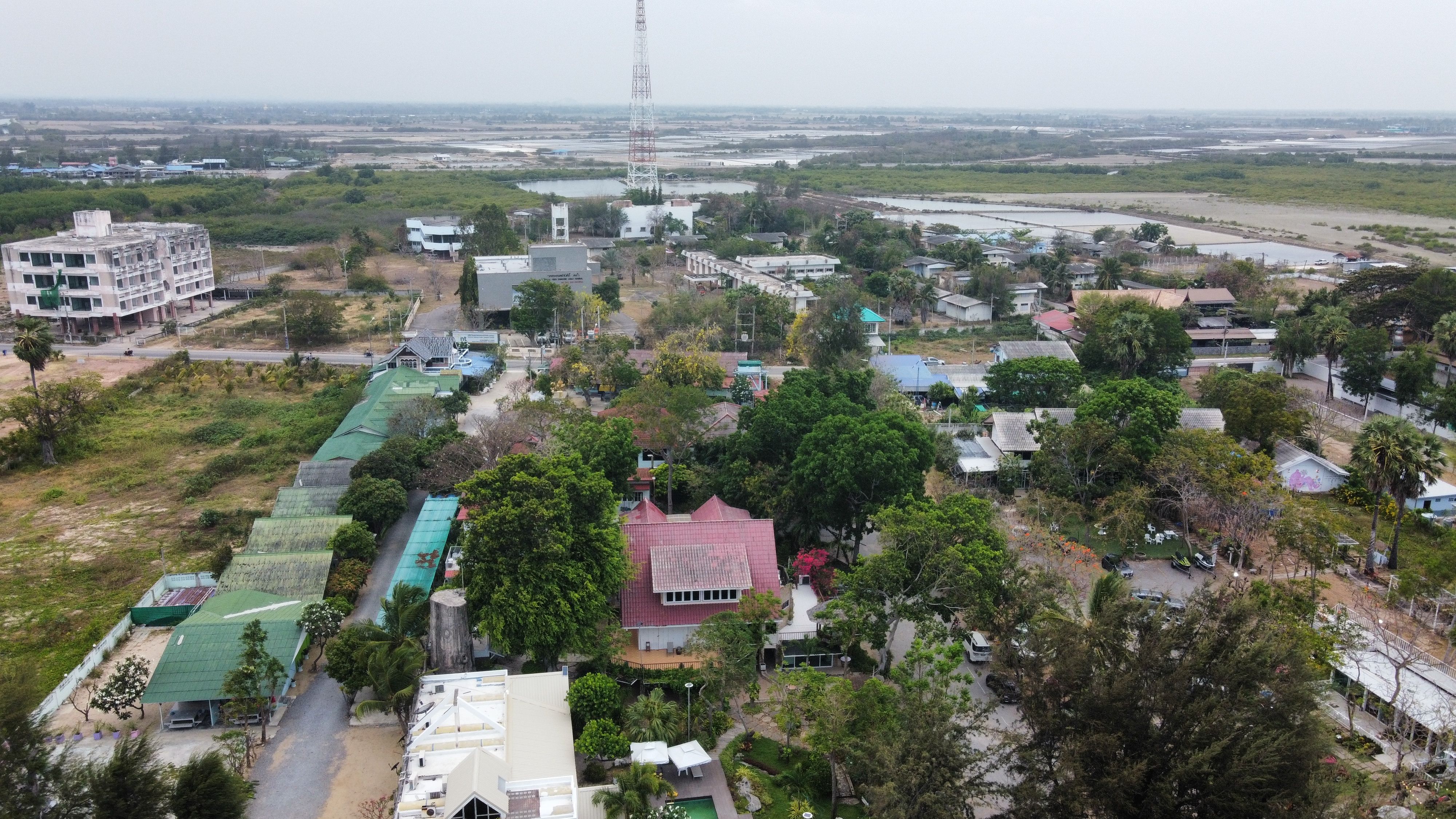 A scenic aerial shot of Tambon Hat Chao Samran, capturing lush greenery and village structures.