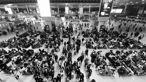 Free Crowd of people walking and sitting in a bustling airport terminal, high angle view. Stock Photo