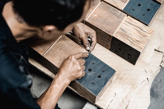 A skilled artisan meticulously works on wooden blocks, showcasing expertise in carpentry and craftsmanship.