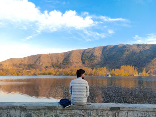 A man sitting on a bench looking out over a lake