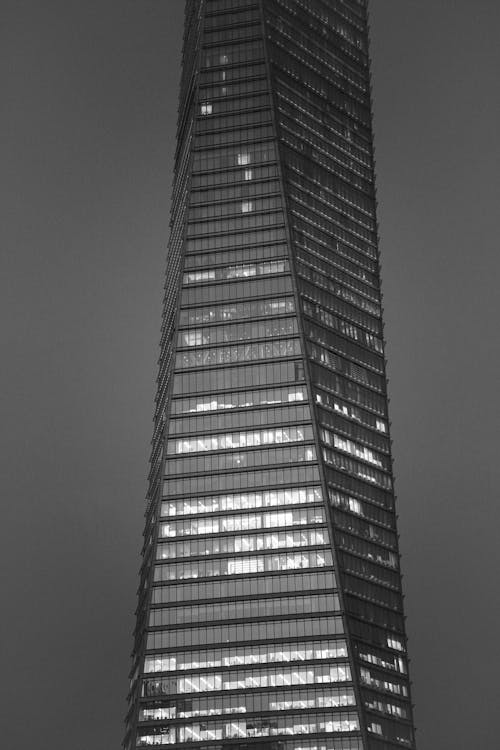 Black and White Photo of a Glass Skyscraper at Night