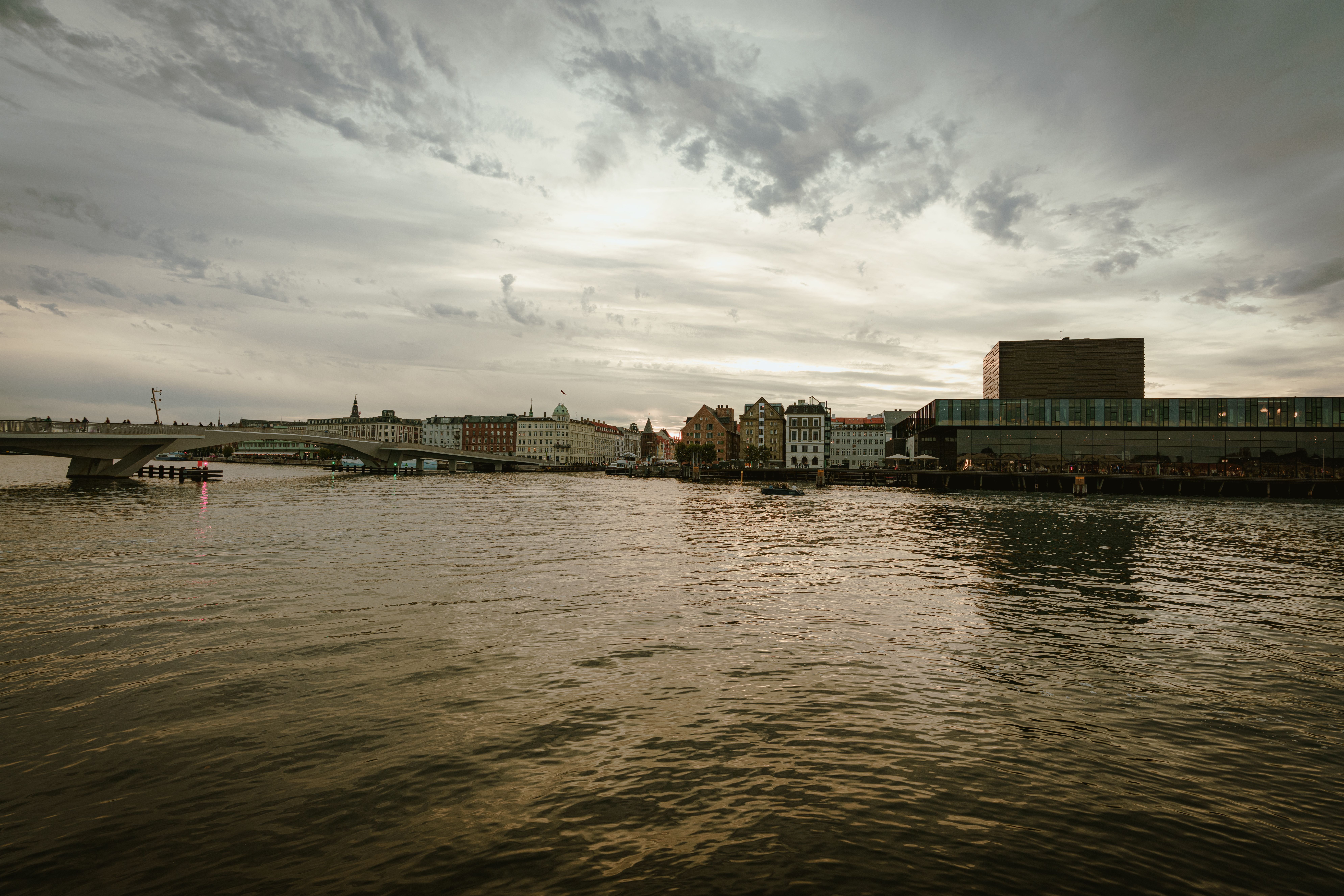 A serene view of a coastal city with buildings and water at dusk, highlighting urban tranquility.