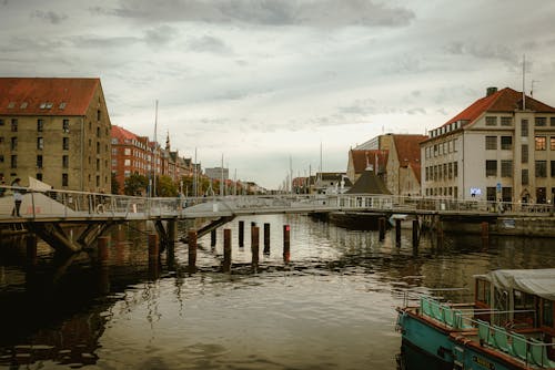 People Walking on Bridge above Canal on Sunset