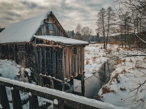 Wooden Barn by the Stream in Winter 