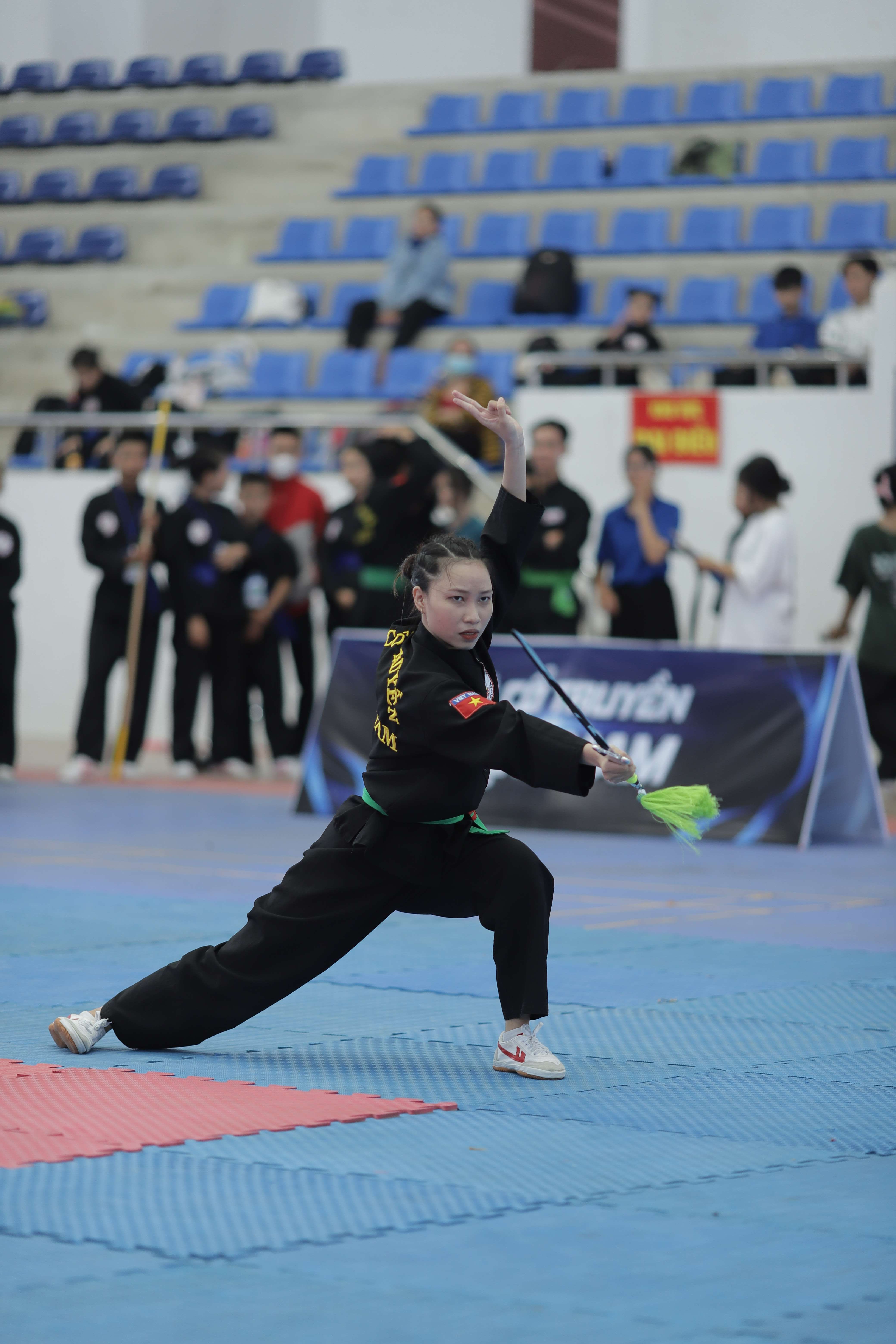 Martial artist showcasing skills during an indoor tournament, captured in action.