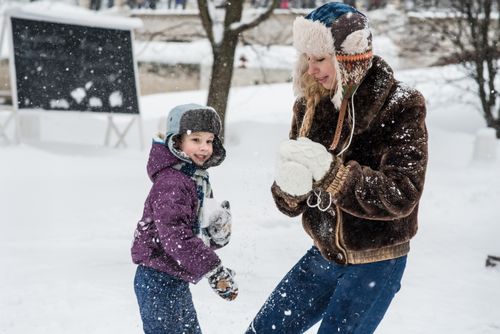 Free Mother and son enjoy a playful snowball fight, embracing the winter wonderland. Stock Photo