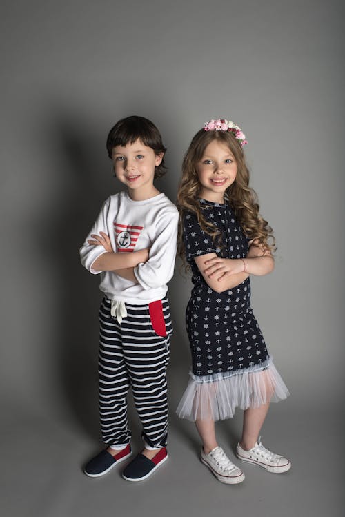 Два мальчика и девочка стоят в одежде
