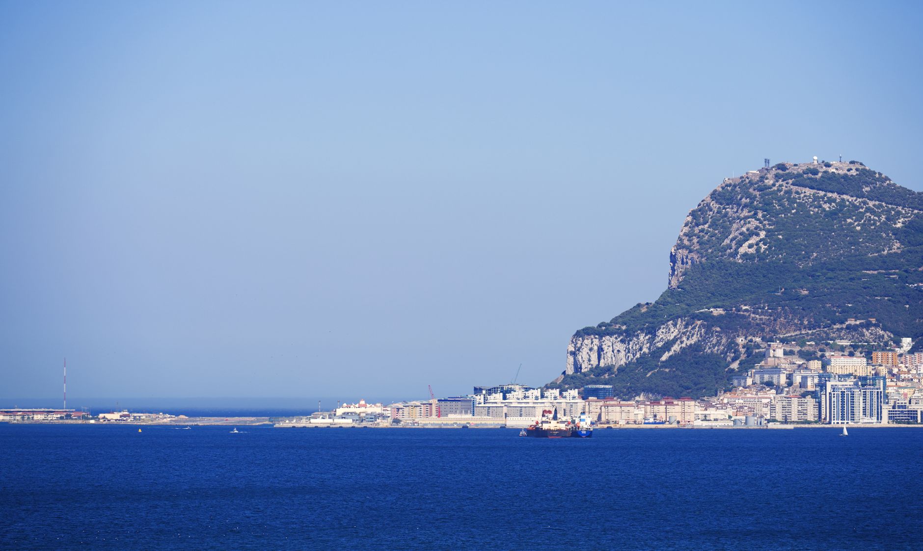 Scenic view of the iconic Rock of Gibraltar, with clear blue sky and sea, ideal for travel imagery.