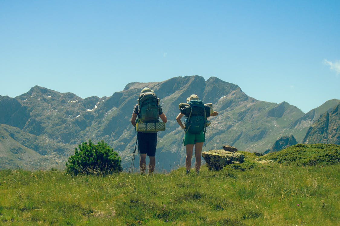 Woman and Man Hiking in Mountains · Free Stock Photo