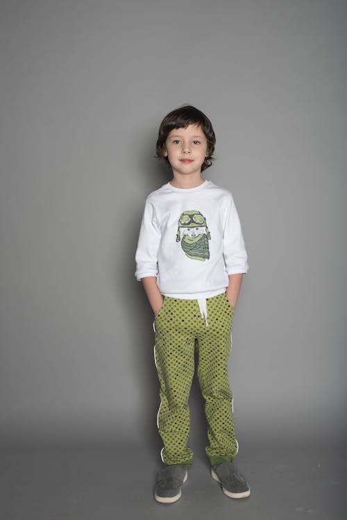Free Boy Wearing White and Green T-shirt and Green Pants Stock Photo
