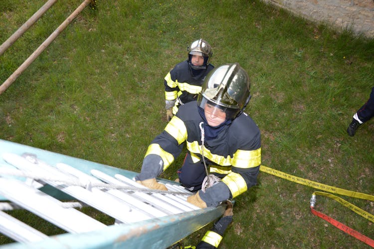 A Female Firefighter Climbing A Ladder 