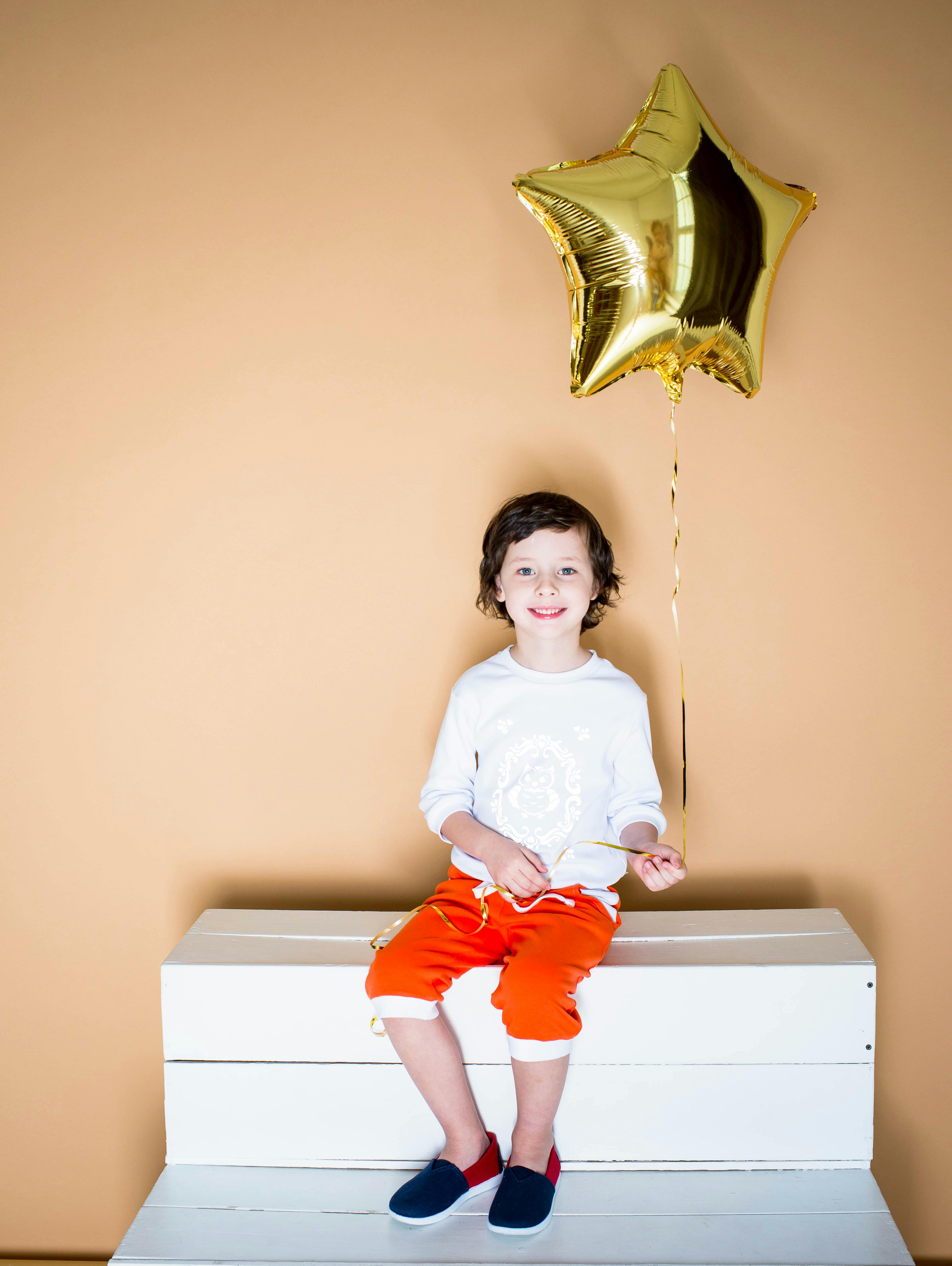 坐在金星气球上的孩子快乐地散发着喜悦和兴奋