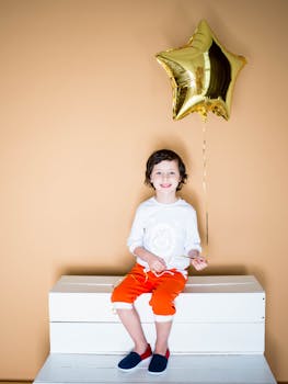 坐在金星气球上的孩子快乐地散发着喜悦和兴奋