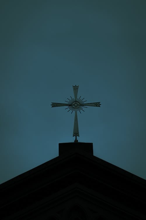 Low Angle Shot of a Cross on a Church Roof on the Background of a Clear Sky