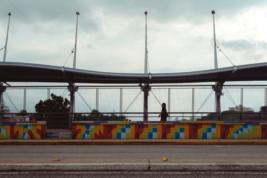 A vibrant and artistic pedestrian bridge in Mérida, Venezuela, on a cloudy day.