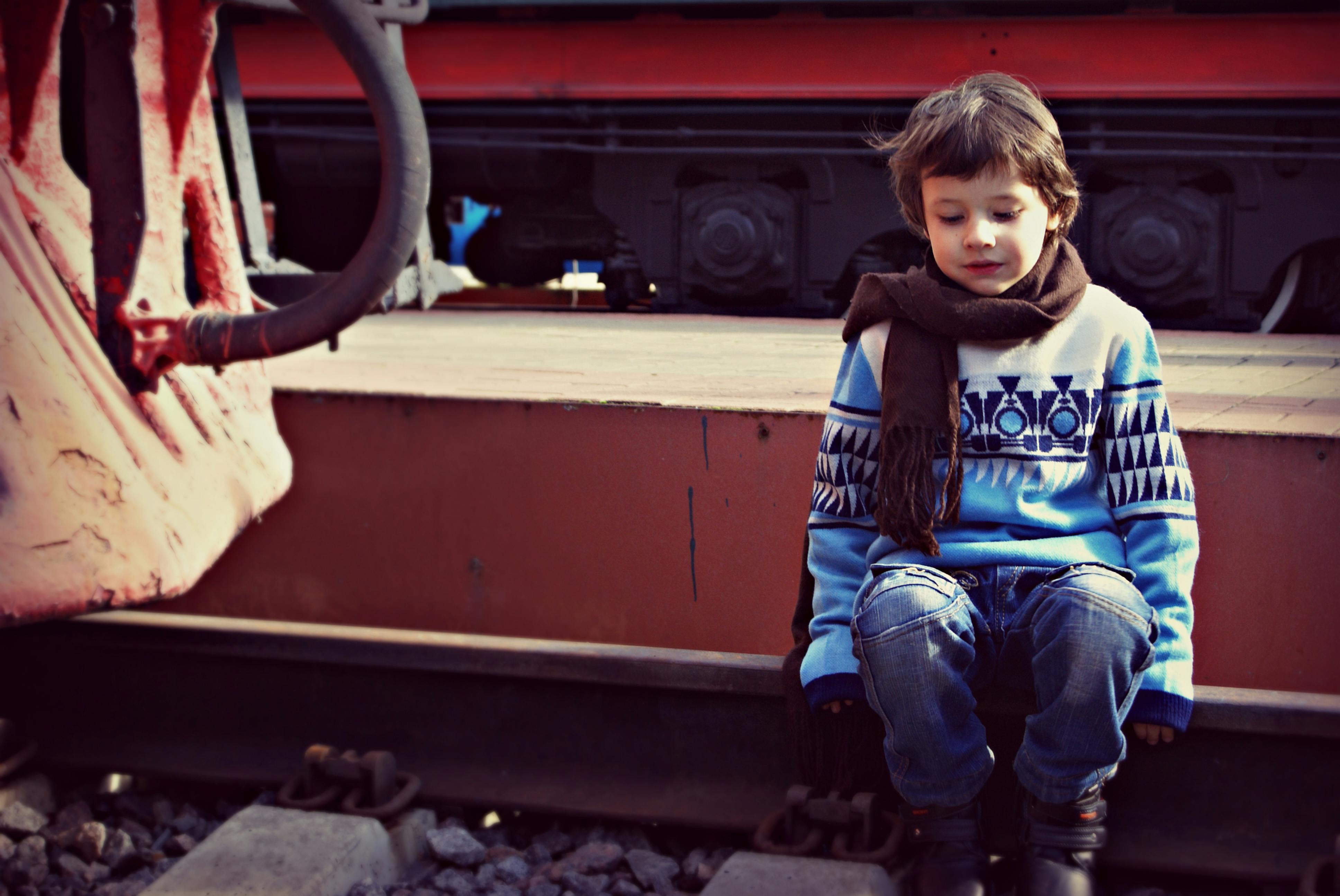 Boy Sitting on Train Rail · Free Stock Photo