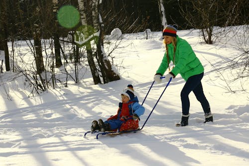女人在雪橇上推蹒跚学步