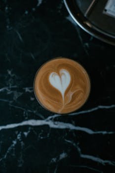 Close-up of a cappuccino with heart latte art on a dark marble table in Istanbul.