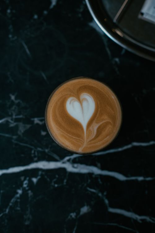 Free Close-up of a cappuccino with heart latte art on a dark marble table in Istanbul. Stock Photo
