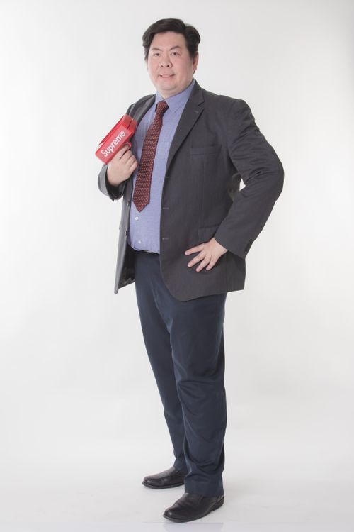 Free Asian man in a suit holding a branded box, showcasing elegance and style on a white background. Stock Photo