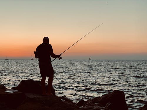adam, akşam karanlığı, Balık tutmak içeren Ücretsiz stok fotoğraf