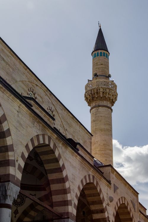 Free Upward view of a historic mosque's minaret and arches in Konya, capturing its stunning architectural detail. Stock Photo
