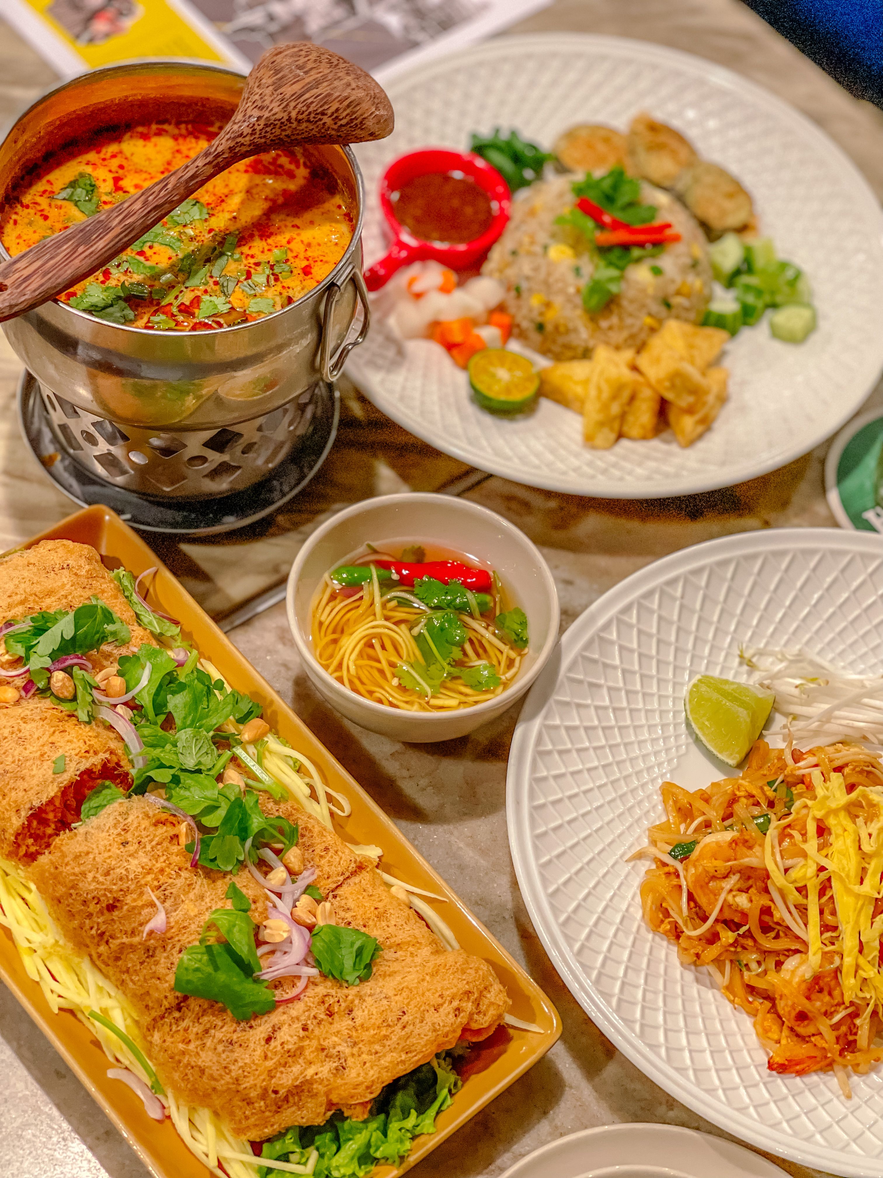 A vibrant selection of authentic Vietnamese dishes featuring noodles, soup, and fresh herbs.