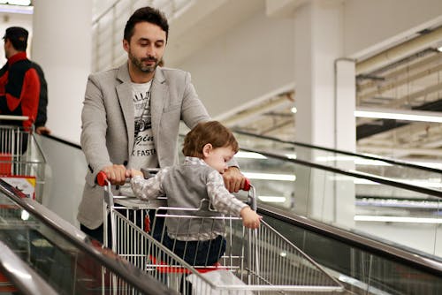 Pria Mendorong Gerobak Pembeli Dengan Baby Sitting Inside