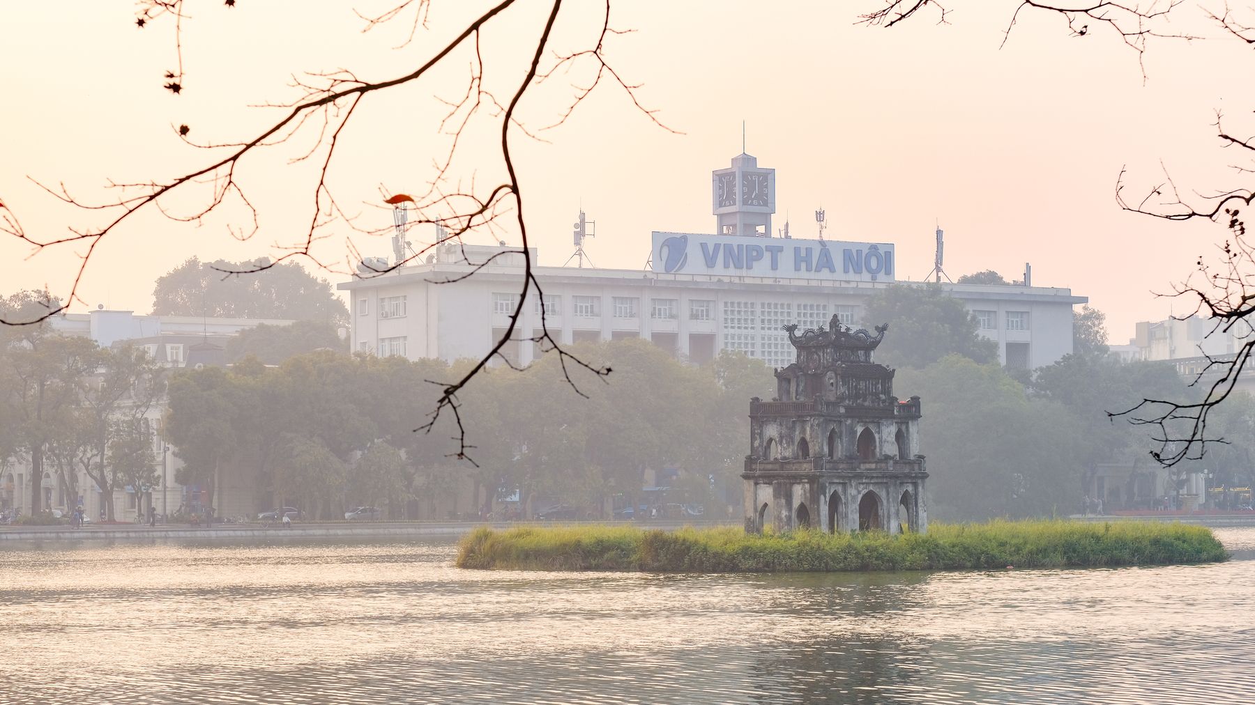 Khung cảnh thơ mộng của Tháp Rùa trên Hồ Hoàn Kiếm, Hà Nội, với ánh sáng buổi sáng sương mù.