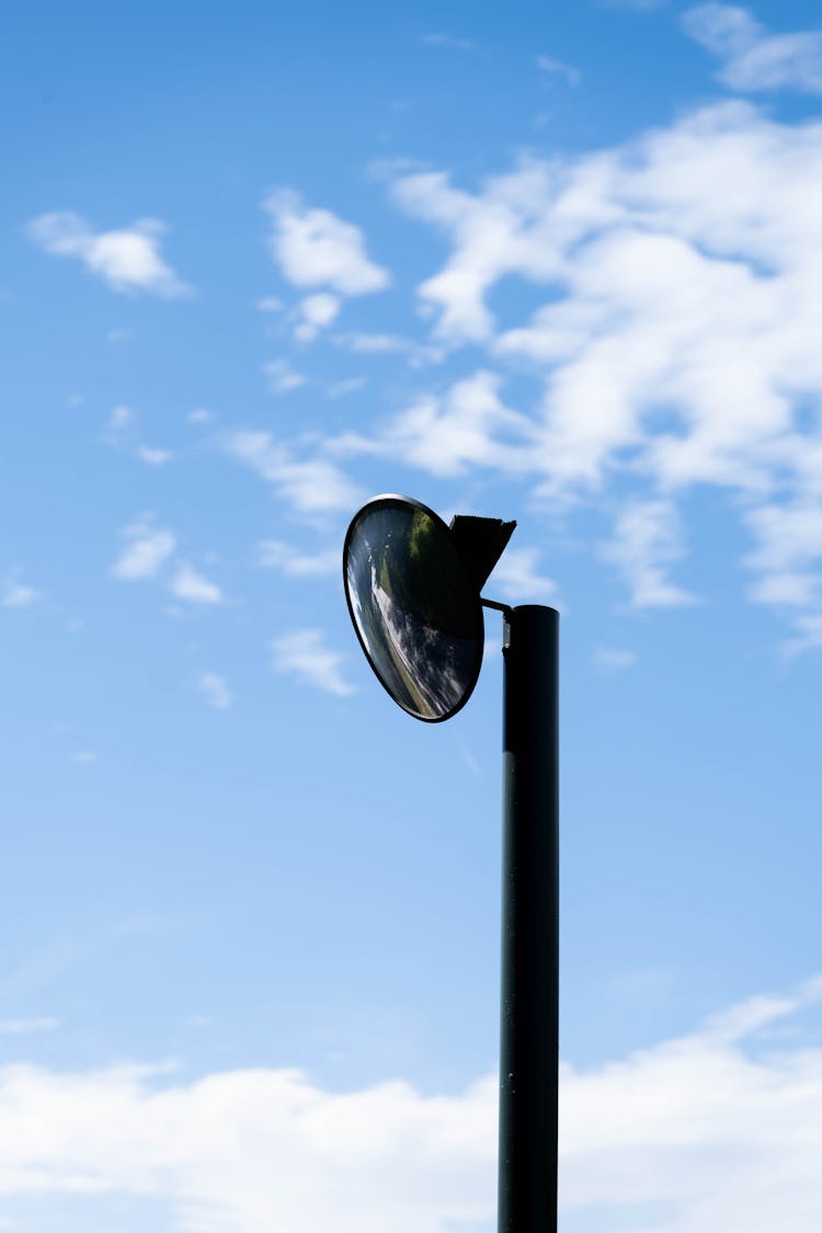 Mirror On Post Under Blue Sky With Clouds