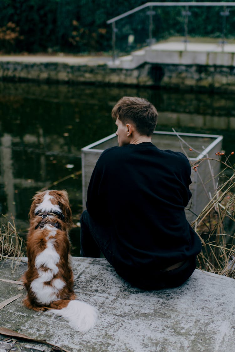 Man Sitting With Cavalier King Charles Spaniel