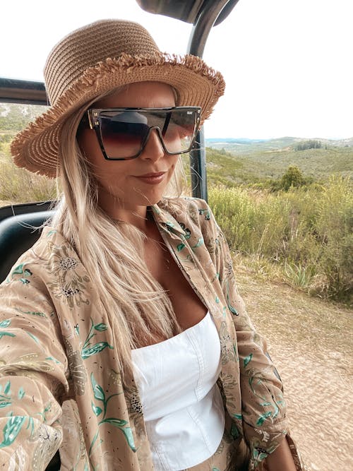 Portrait of a Young Woman Wearing Sunglasses and a Sun Hat