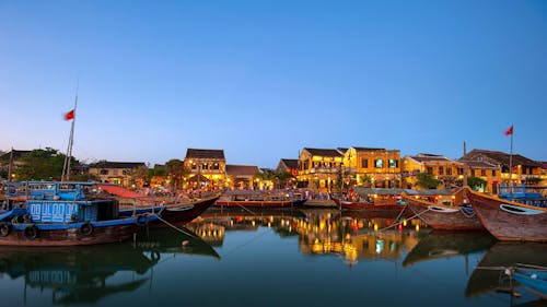 Barche Su Acque Calme Vicino A Edifici Sotto Il Cielo Blu