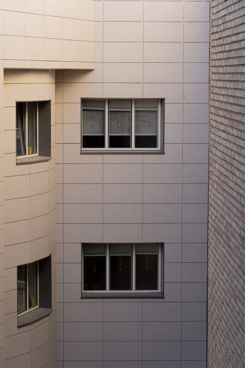 Free Close-up of a modern building facade with multiple windows, showcasing urban architecture. Stock Photo